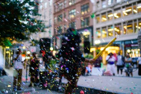 Confetti, in front of a blurred city street.