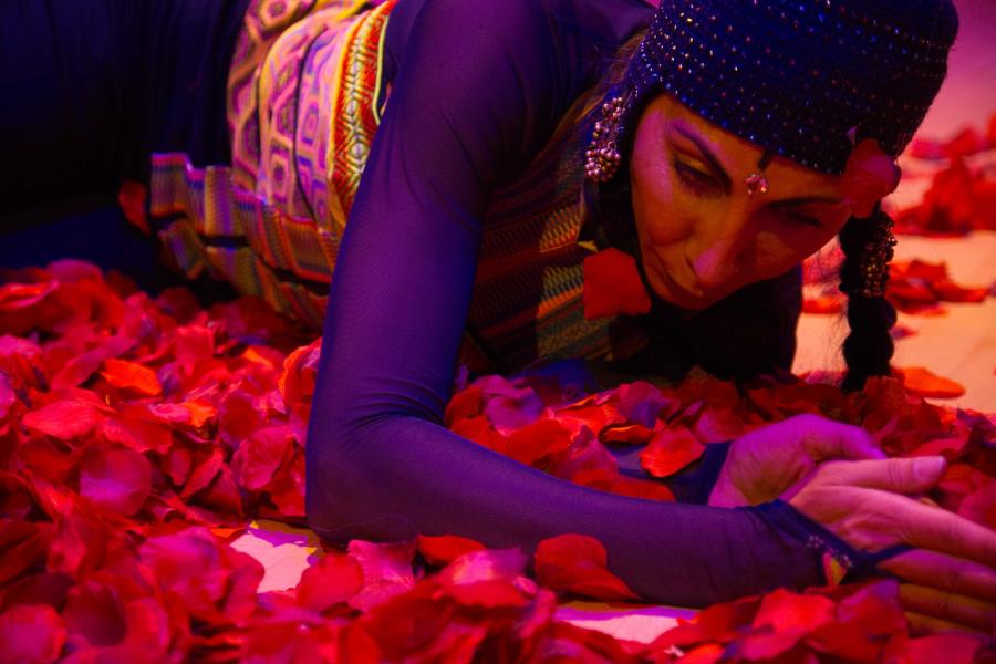 A woman rolls around in rose petals.