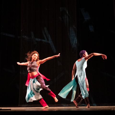 Two dancers twirl away from each other.