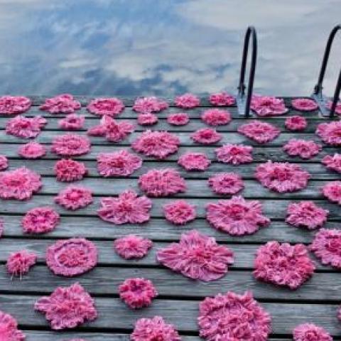 Pink paper flowers on a deck.