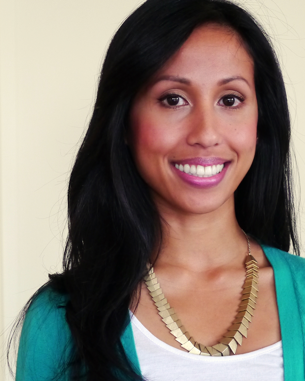 A smiling woman in a teal cardigan