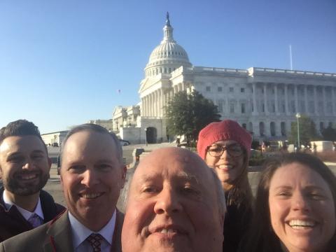 Five people smile for a selfie in front of the US Capital Building