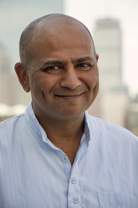 A man wearing a blue button downs shirt.