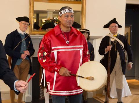 Larry plays the drum wearing Nipmuc traditional attire at the Concord museum