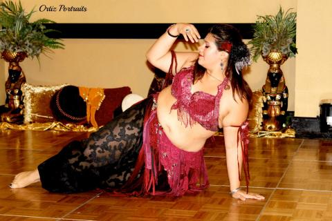 A woman in belly dancer attire strikes a dance pose
