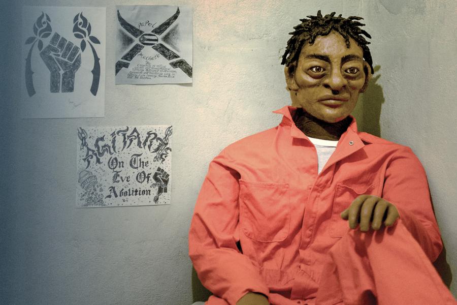 Poster design with a puppet in an orange jumpsuit in a prison cell with drawings taped to the wall.